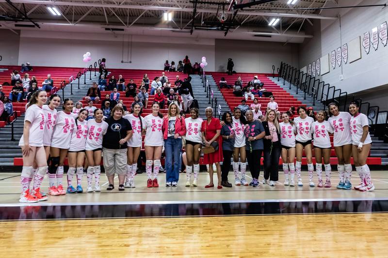 The Bolingbrook varsity volleyball team takes a photo with the women they are honoring with a Pink Out Night prior to competing against Joliet West at Bolingbrook High School on Oct. 16, 2025.