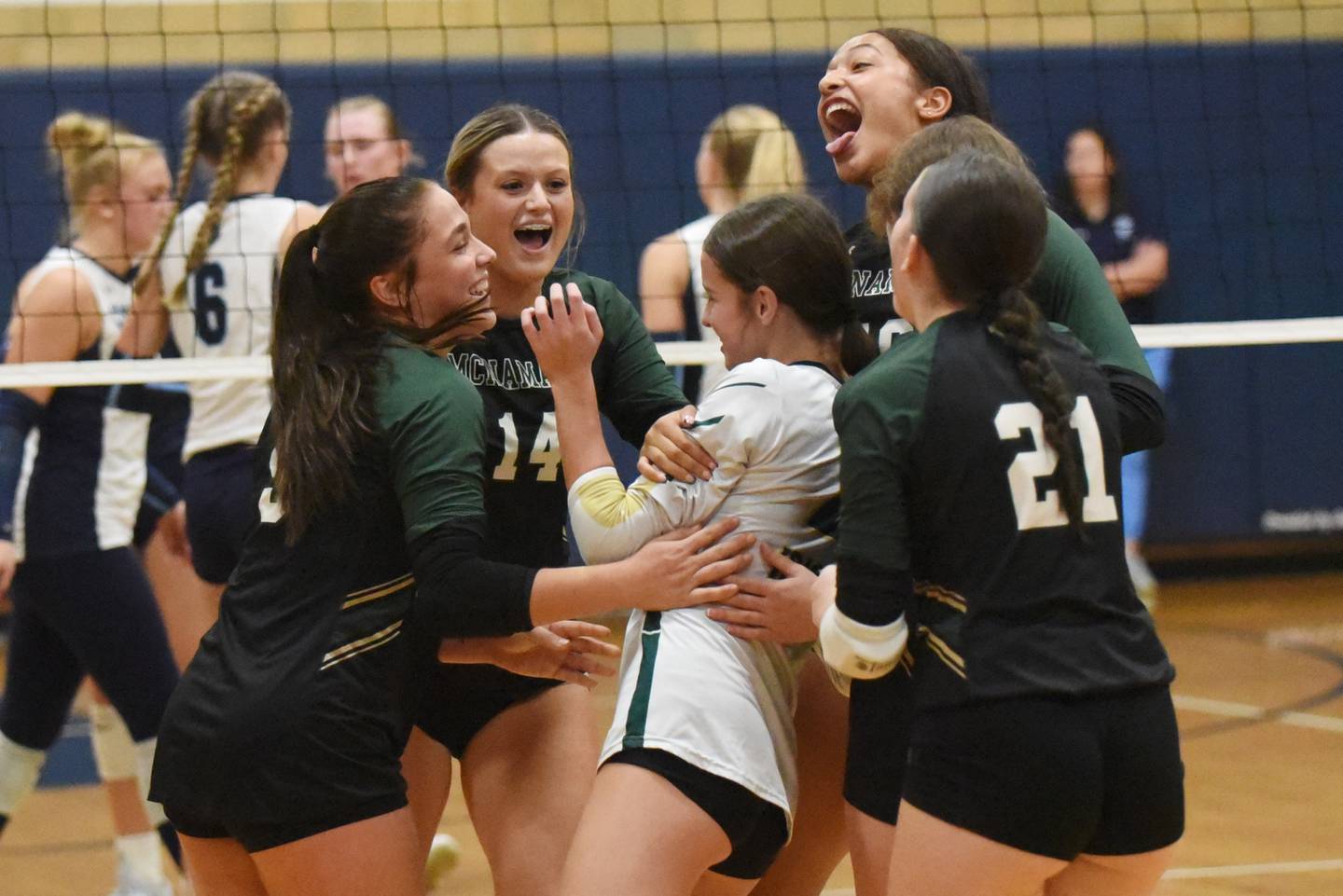 Members of the Bishop McNamara girls volleyball team congratulate Gianna Brosseau, center, on her diving dig that landed over the net for a point during the Fightin' Irish's game at Cissna Park Wednesday, Oct. 15, 2025.