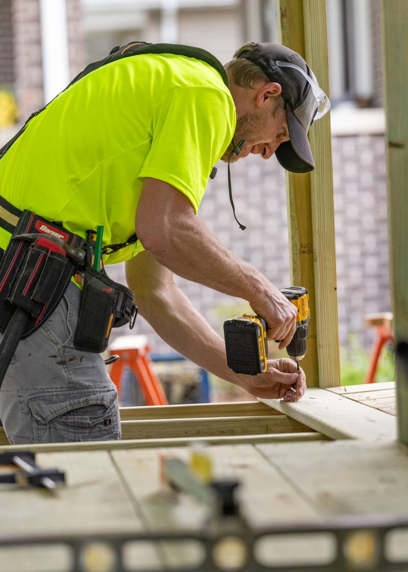Andy Barnes installs screws into decking board as part of a wheelchair access ramp at a private residence on June 6, 2025 in Peru.