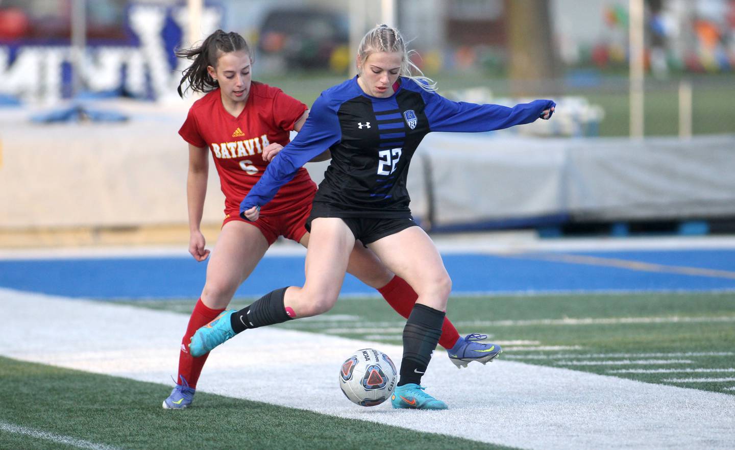 Geneva’s Morgan Rudowicz (22) and Batavia’s Carlin King go after the ball during a Tri-Cities Night game at Geneva High School on Tuesday, April 26, 2022.