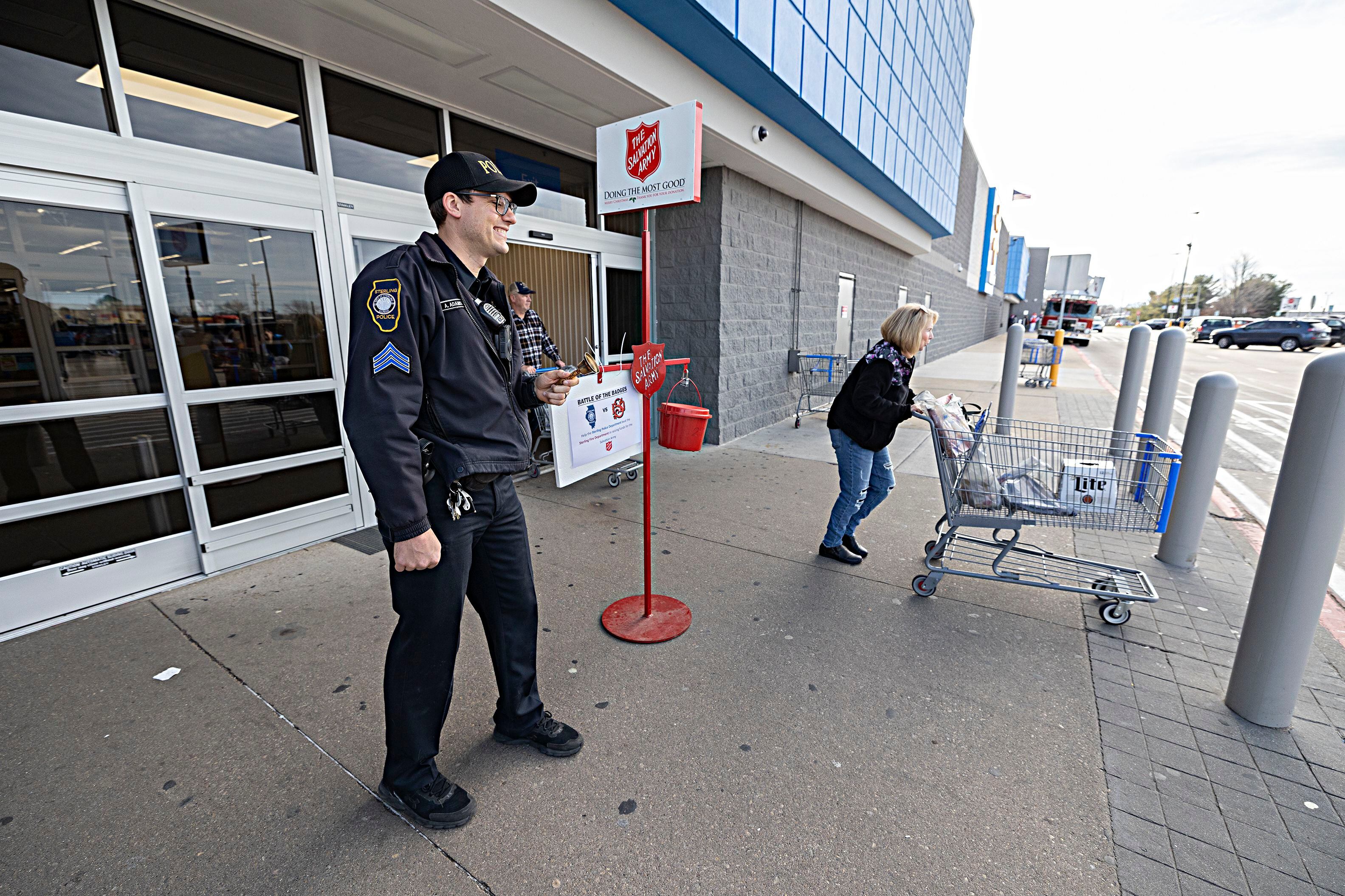 Sterling police officer Anthony Adamson mans the east entrance Friday, Dec. 15, 2023 at Sterling Walmart for the Sterling Fire vs. Police Salvation Army challenge.
