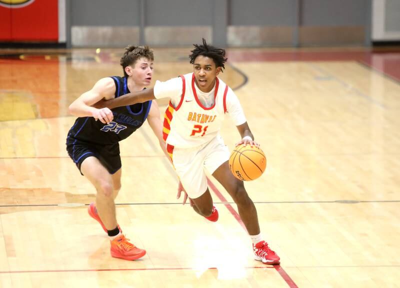 Batavia’s Xavier Justice drives the ball past St. Charles North’s TJ Gleason during a game on Wednesday, Dec. 11, 2024 in Batavia.