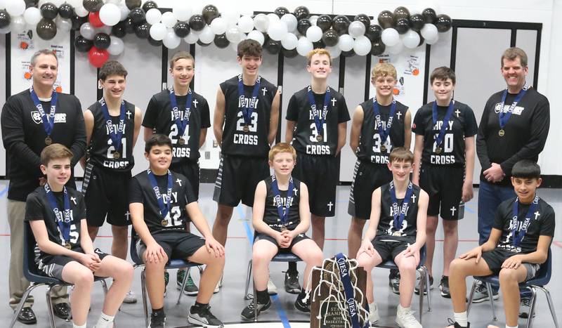 Members of the Mendota Holy Cross eighth-grade boys basketball team pose with the Class 1A State chamipionship trophy during a reception on Tuesday, Feb. 20, 2024 at Holy Cross School. The team beat Pana Sacred Heart 41-33 to win the IESA Class 1A State championship.