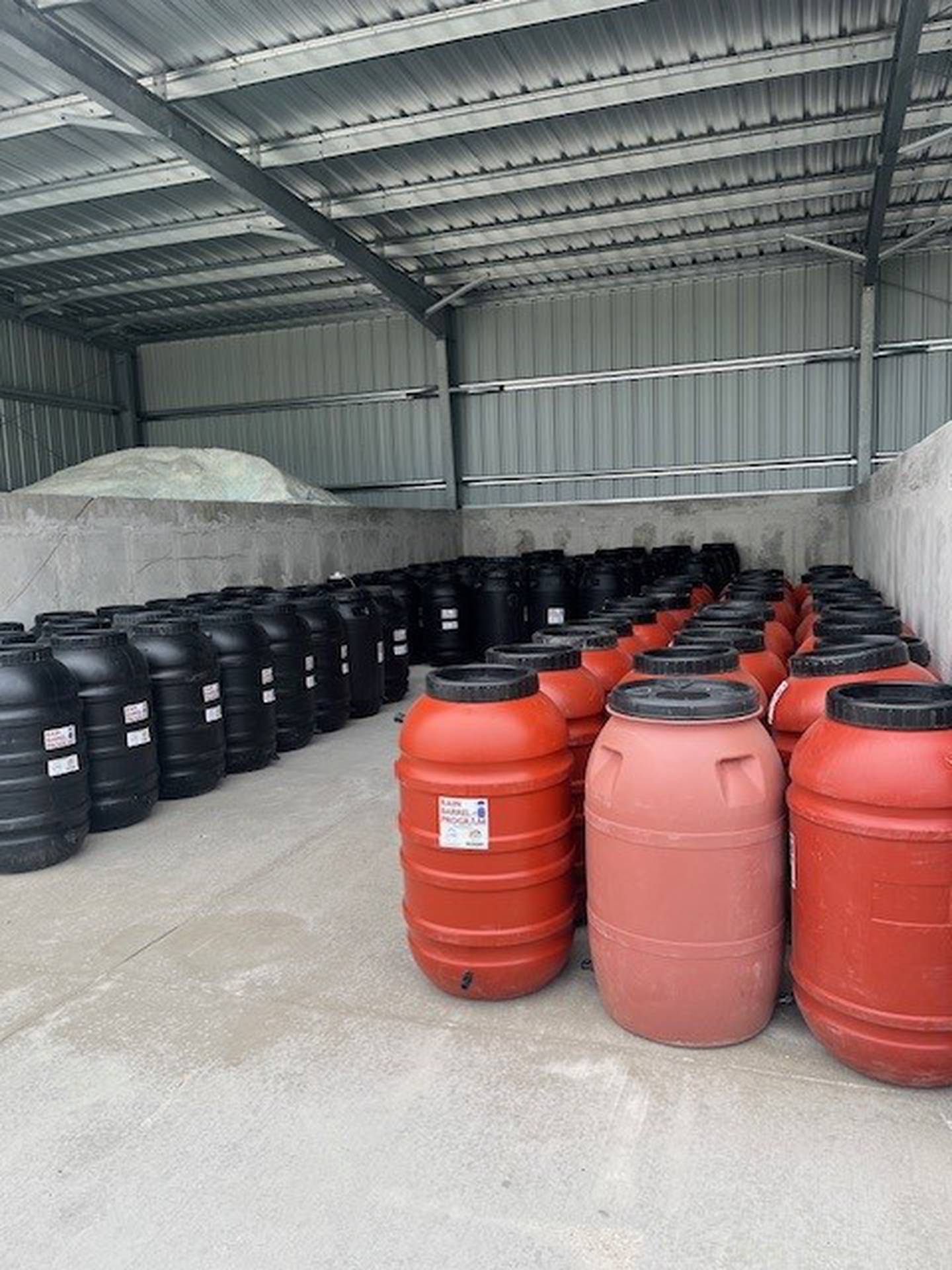 Rain barrels sit in storage waiting for residents to pick them up.