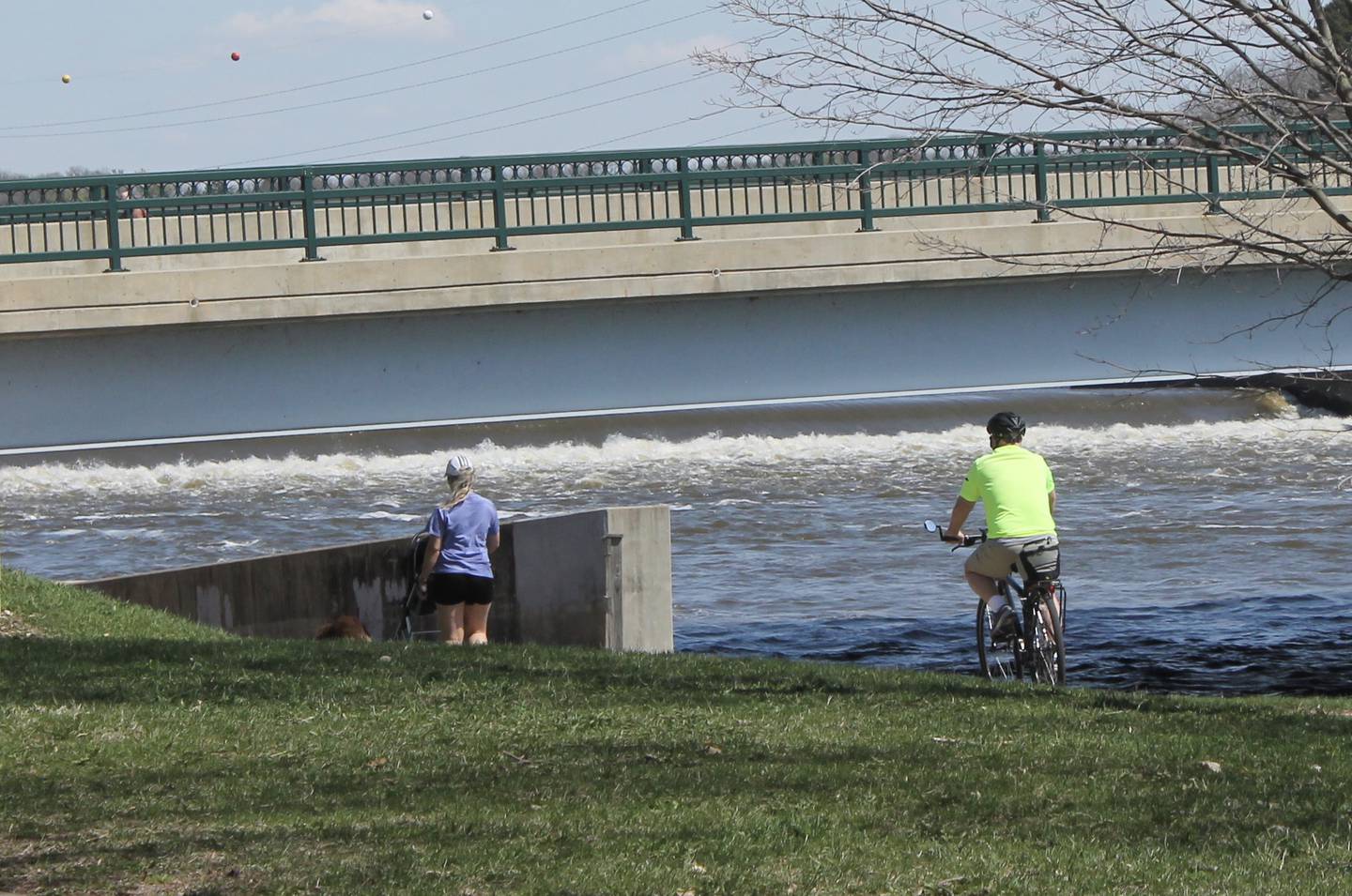 A cyclist and a dog-walker turn onto the path under the Galena Avenue bridge on Tuesday, April 11, 2023. Dixon was awarded a $2.25 million state grant for bike path extension.