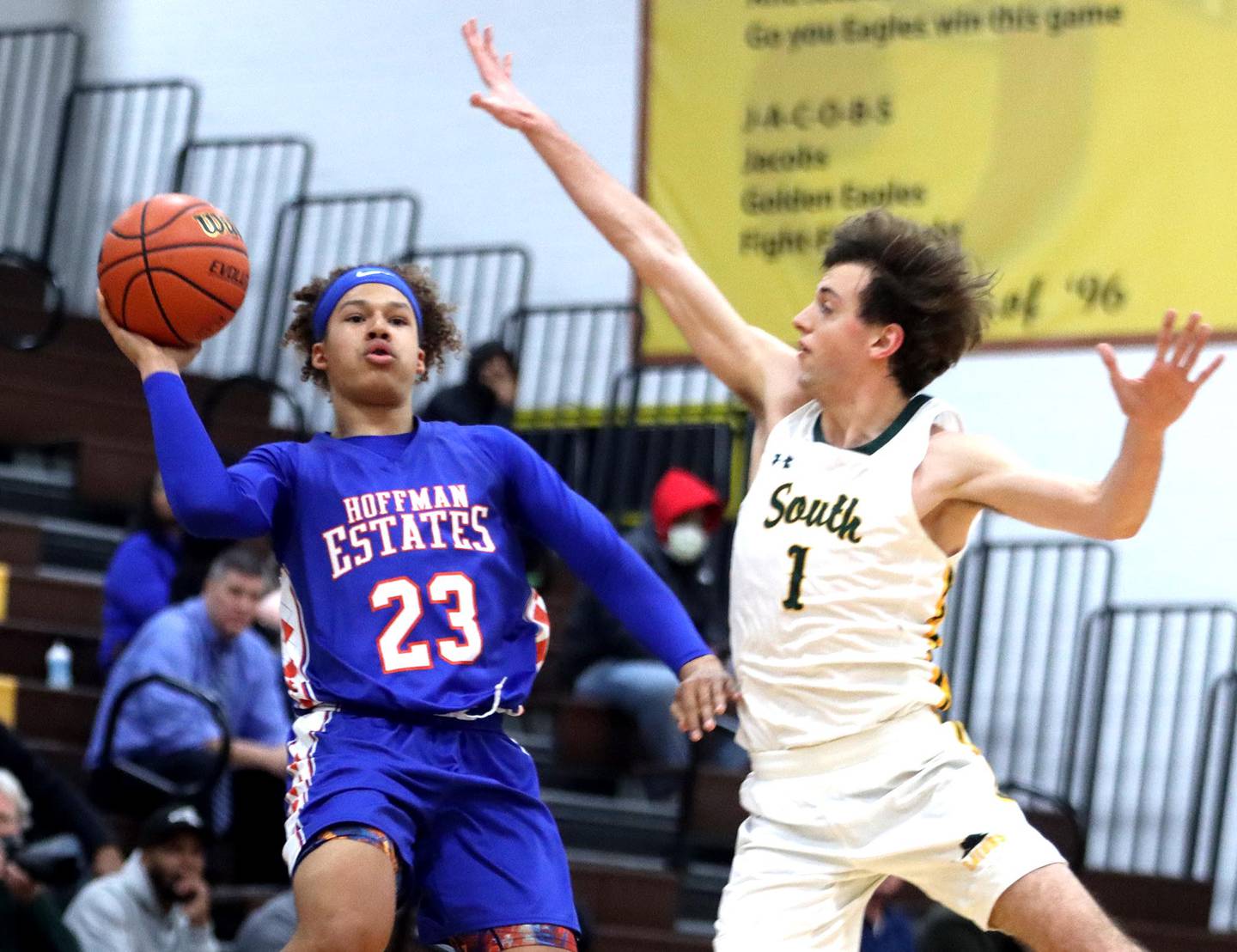 Crystal Lake South’s Zachary Peltz, right, blocks as Hoffman Estates’ Nate Cleveland launches a shot during Hinkle Holiday Classic Basketball Tournament action at Jacobs High School Thursday.
