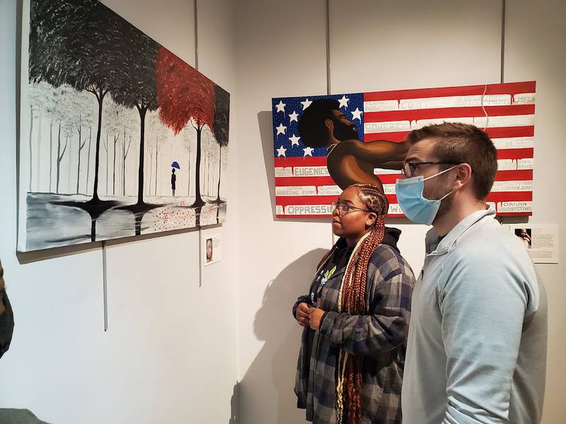 Autumn Sky Collier stands with Timothy Baran of Joliet in the Joliet Area Historical Museum as he admires her artwork and asks questions about it. Autumn's piece will remain with the the Joliet Focus “Our Community, Your Experience” exhibit at the museum until the exhibit ends on Friday, Dec. 31, 2021.