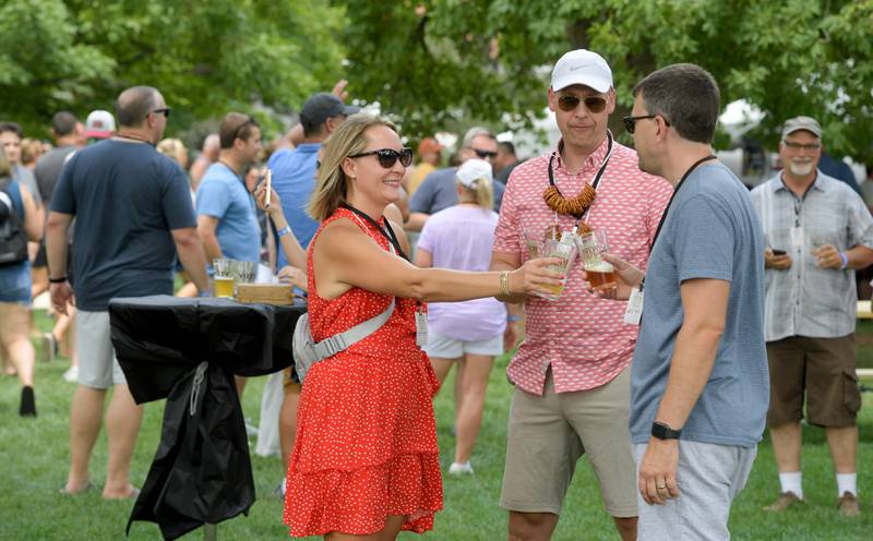 Erin Hack, Randy Bruns and Chris Hack enjoy some beers during the Wheaton Brew and Seltzer Fest in Memorial Park on Saturday, August 6, 2022.