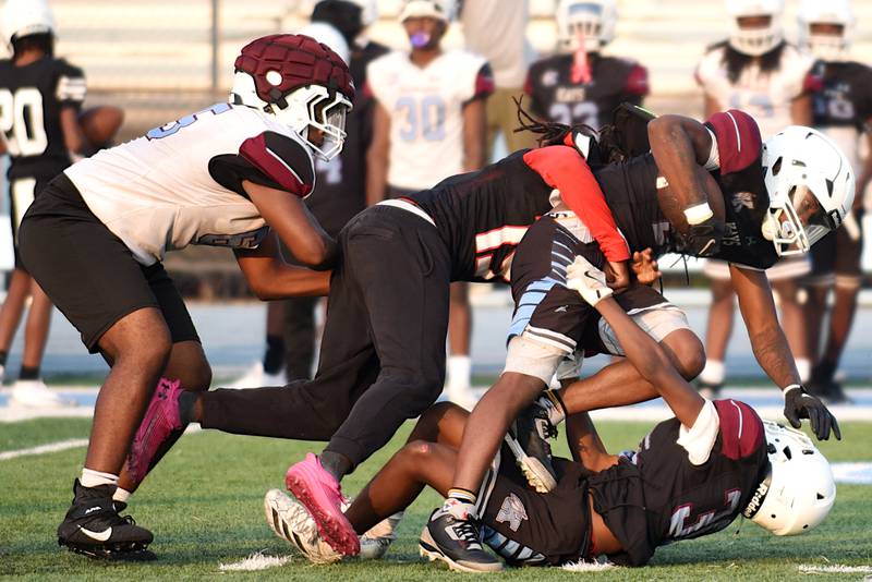 Kankakee's Zion Thomas, center, brings Jaymari Hairston to the ground during a scrimmage at the Kays' summer camp Thursday, July 31, 2025.