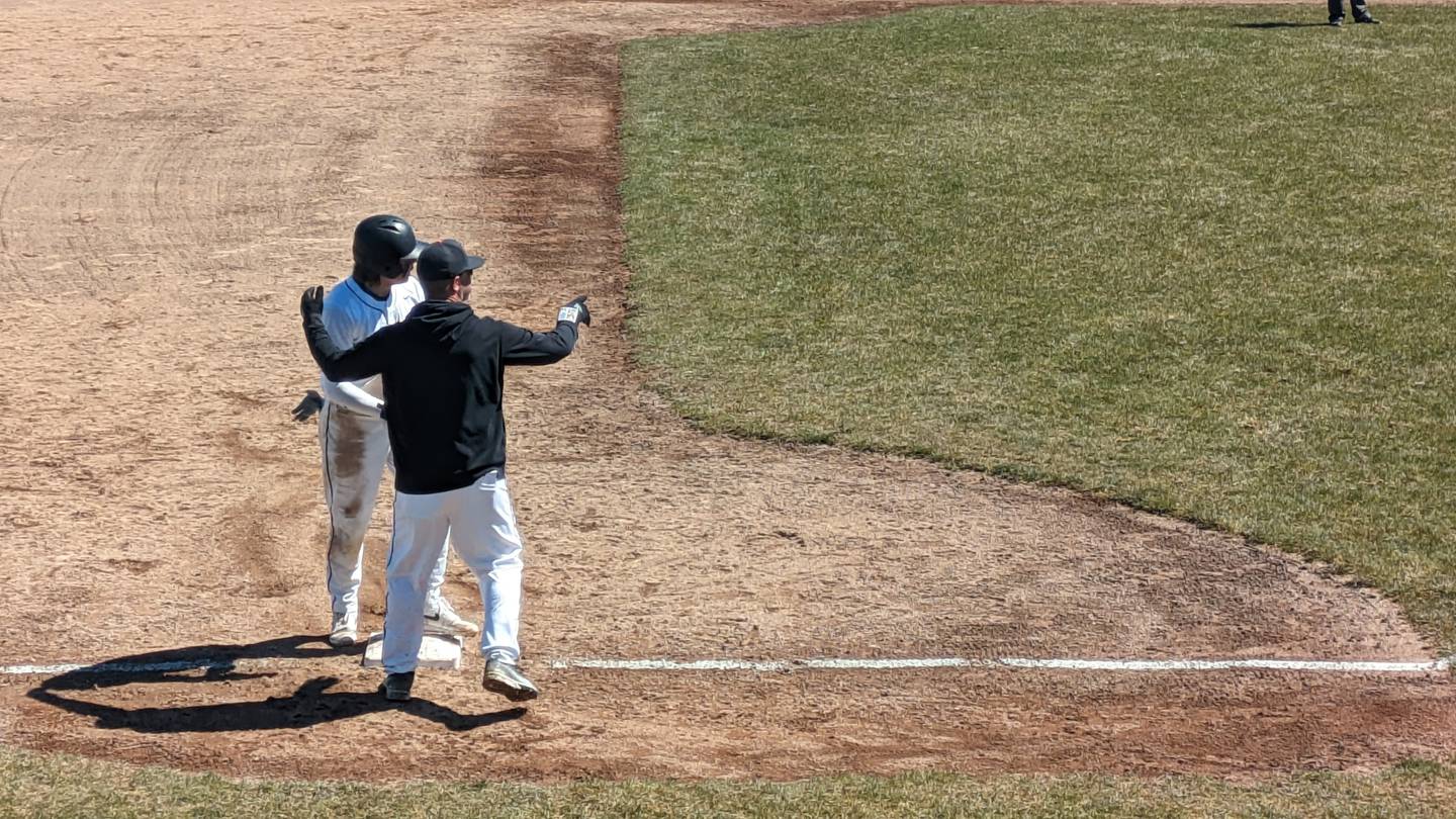 DeKalb left fielder Brodie Farrell takes instructions from coach Josh Latimer after hitting a game-tying triple in the fifth inning of the Barbs' 2-1 win against Kaneland on Saturday, April 6, 2024.