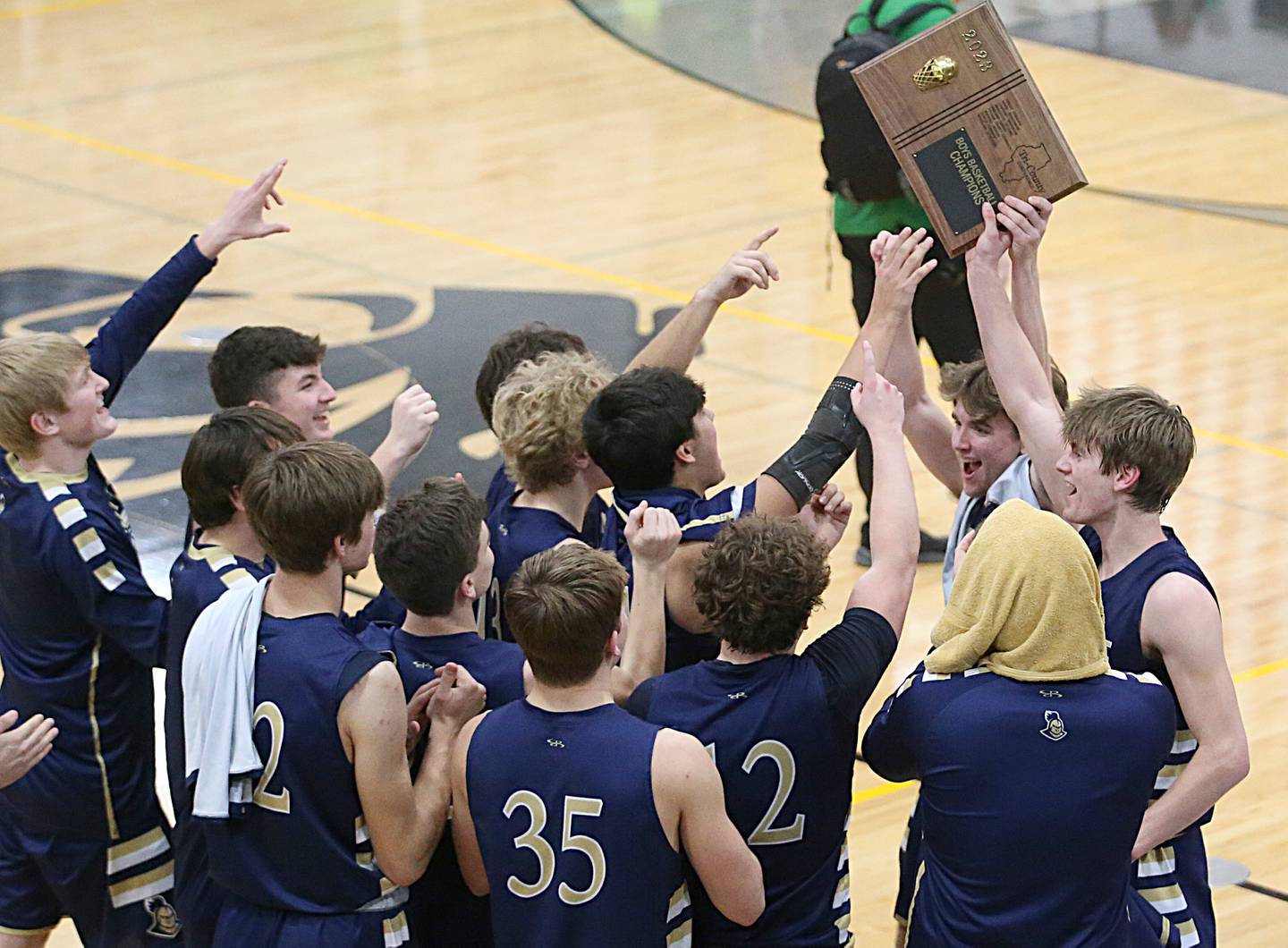 Members of the Marquette boys basketball team hoist the 2023 Tri-County championship trophy after defeating Seneca in the championship game on Friday, Jan. 27, 2023 at Putnam County High School.