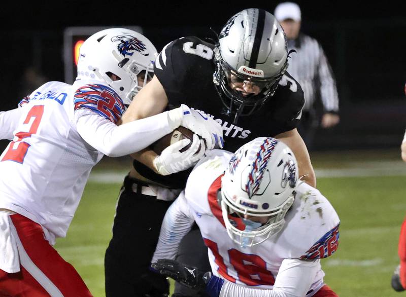 Kaneland's Carter Grabowski is brought down by Lakes' Ethan Gialo (left) and Mason Gialo Saturday, Nov. 1, 2025, during their first round playoff game at Kaneland High School in Maple Park.