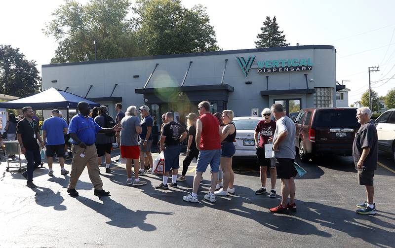 People wait in line for former Bears quarterback Jim McMahon to signs autographs and pose for pictures with customers during the grand opening of the Vertical Dispensary on Saturday, Sept. 30, 2023, in Cary. The dispensary has been open for about a month.