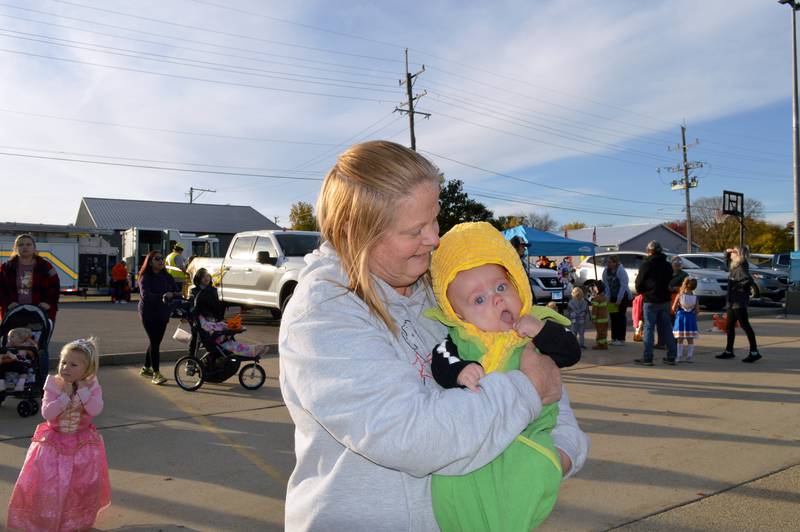 Tammy Ludwig, of Forreston, holds 4-month-old Bensyn Engelbarts, who is dressed as a corncob, on Saturday, Oct. 26, 2024, while attending a trunk-or-treat at Crossroads Community Church's Polo campus.