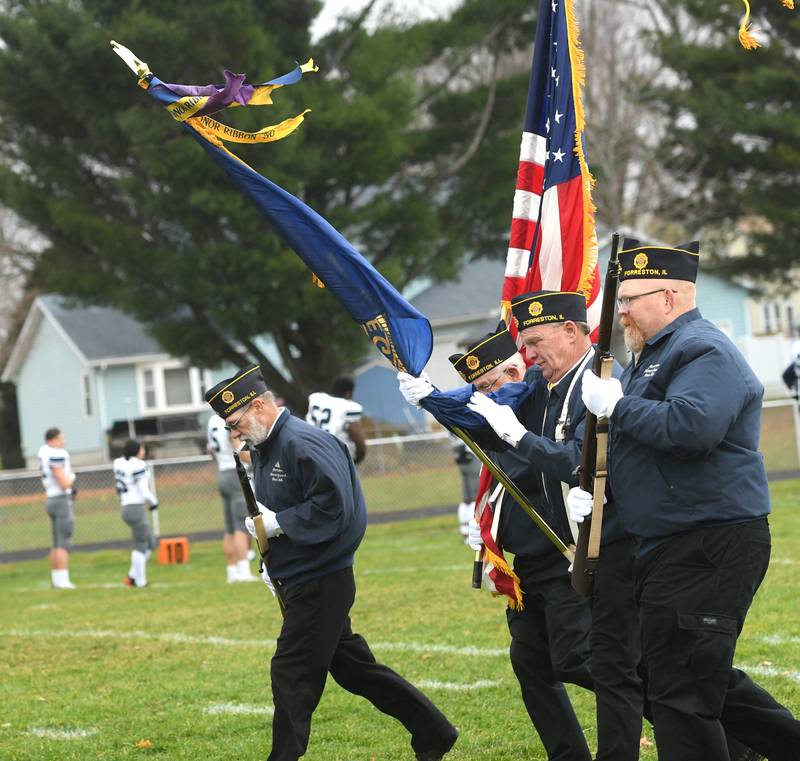 Members of Forreston's American Legion Post 308 Color Guard battled strong winds on Saturday, Nov. 5 when they carried flags to the center of the football field to start the Cardinals' playoff game against Chicago Hope Academy.