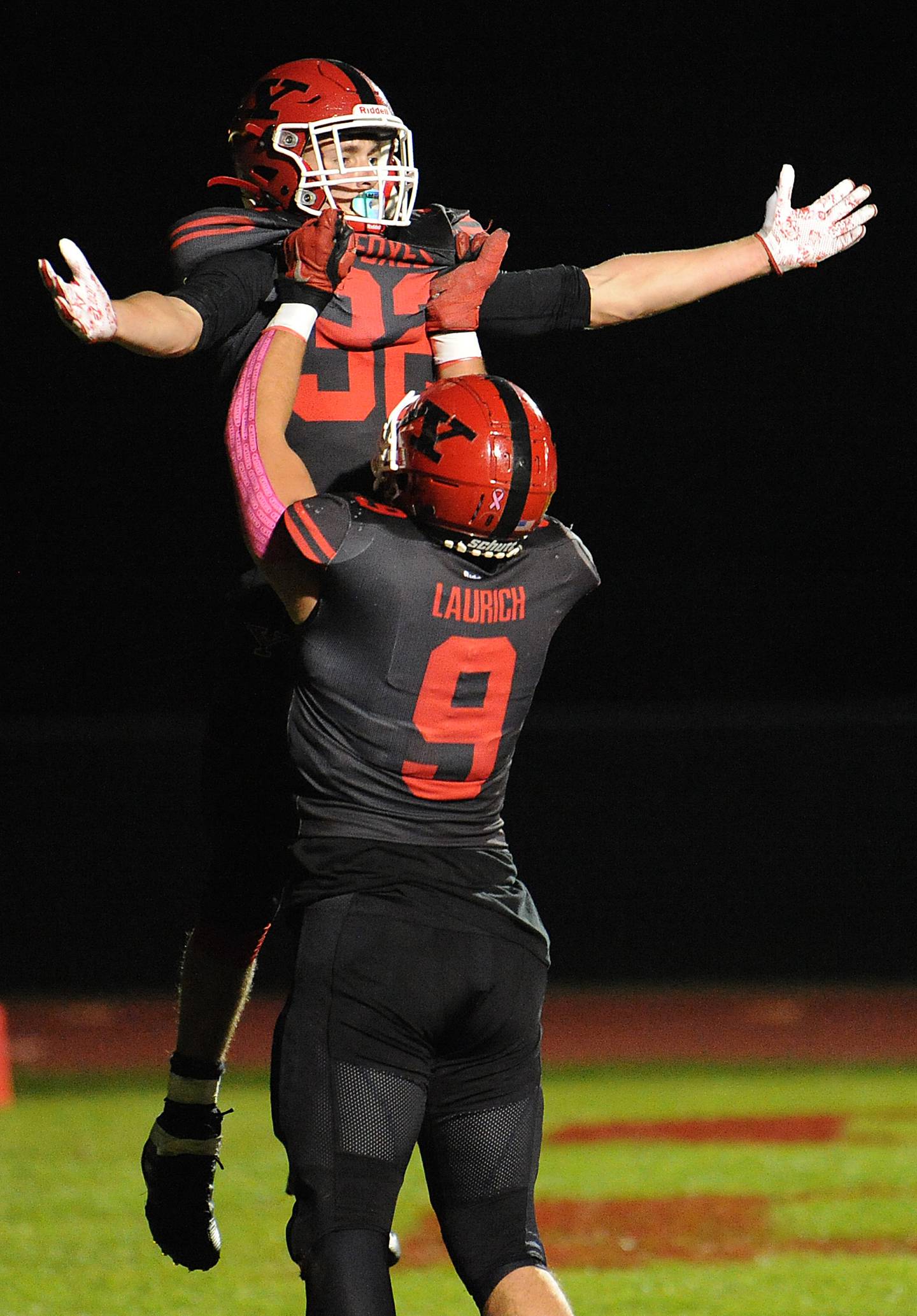 Yorkville tightend Andrew Laurich hoists runningback Gio Zeman into the air, to celebrate a touchdown against Oswego during a varsity football game at Yorkville High School on Friday.