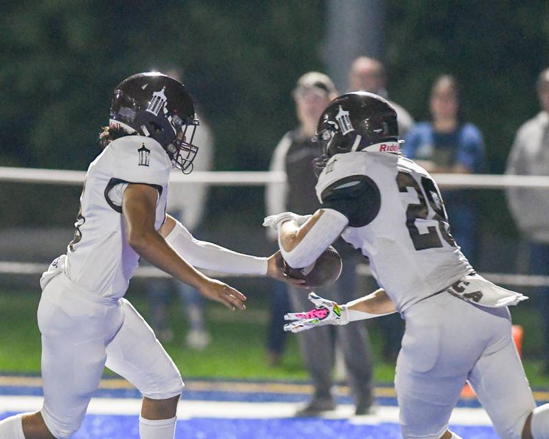 Joliet Catholic's Andres Munoz (left) hands the ball off to teammate Nate Magrini during the first quarter on Friday Sept. 22, 2023, at St. Francis in Wheaton,.