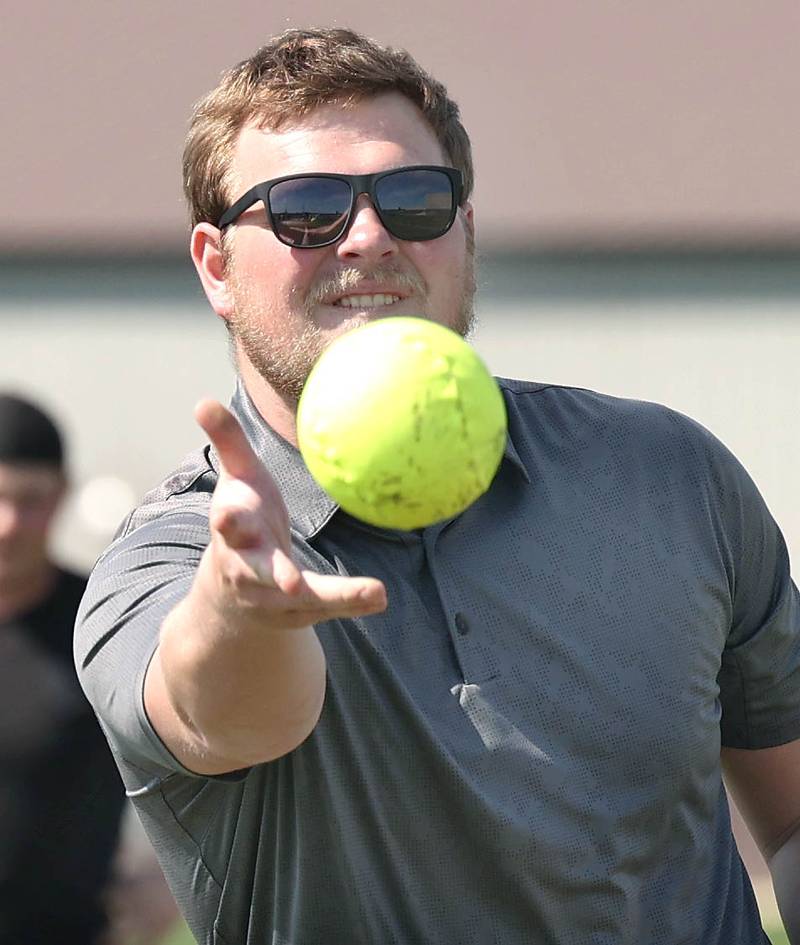 Griffin McNeal, Genoa-Kingston High School physical education teacher, pitches to students in his class Thursday, April 13, 2023, as they get outside to play some softball.