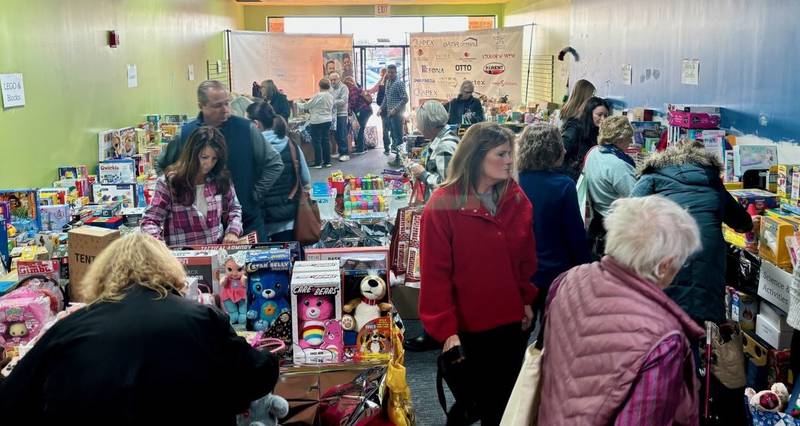 CASA Kane County volunteers look through gift donations for children in foster care as well as other children in the home. New this year was a vacant storefront donated by Corcoran Commercial Real Estate in St. Charles to make it easier for dropping off and picking up gifts.