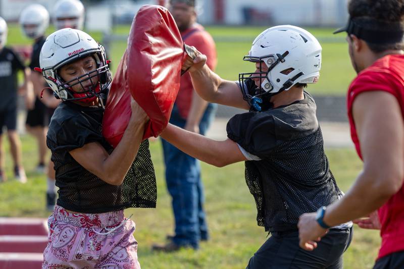 (left to right) Jesus Martinez charges pad as Jorrick Black of Streator holds it on Monday, August 11, 2025 at Streator High School in Streator.