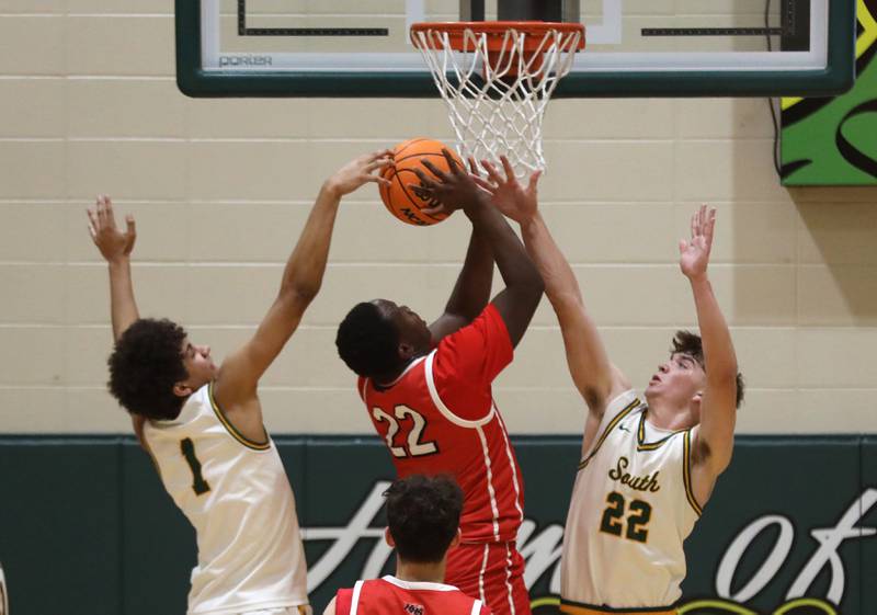Crystal Lake South's Noah Cook (left) and Nick Stowasser (right) try to  blocks the shot of Huntley's Seun Oladipo during a Fox Valley Conference boys basketball game on Friday, Jan. 30, 2026, at Crystal Lake South High School.
