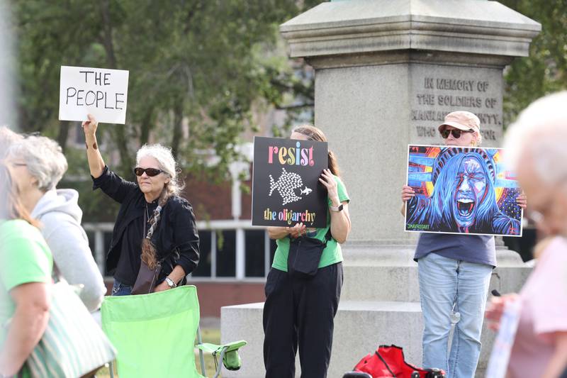 Protesters hold signs during a "Good Trouble Lives On" rally held in Kankakee as part of a national day of peaceful protests on Thursday, July 17, 2025.