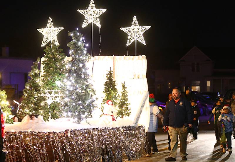 A float with decorative Christmas trees rolls down Peoria Street for the Peru Hometown Christmas parade on Saturday Dec. 4, 2021 in Peru.