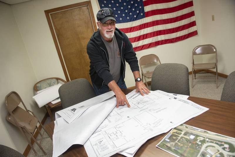 Jordan points out planned renovations on a blueprint of the new museum.