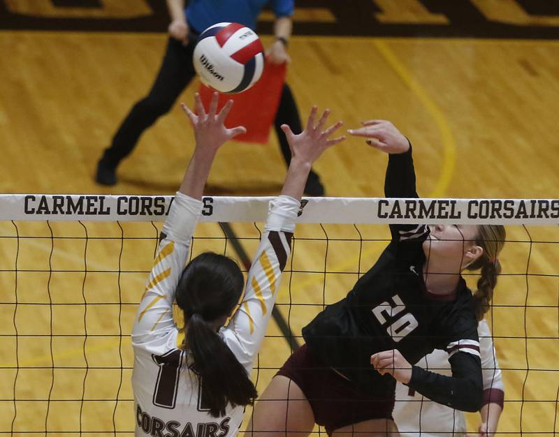 Prairie Ridge's Ava Bell (right) hits the ball away from the block of Carmel’s Charlotte Shepherd during the IHSA Class 3A Carmel Sectional championship volleyball match on Thursday, Nov. 6, 2025, at Carmel High School, in Mundelein.