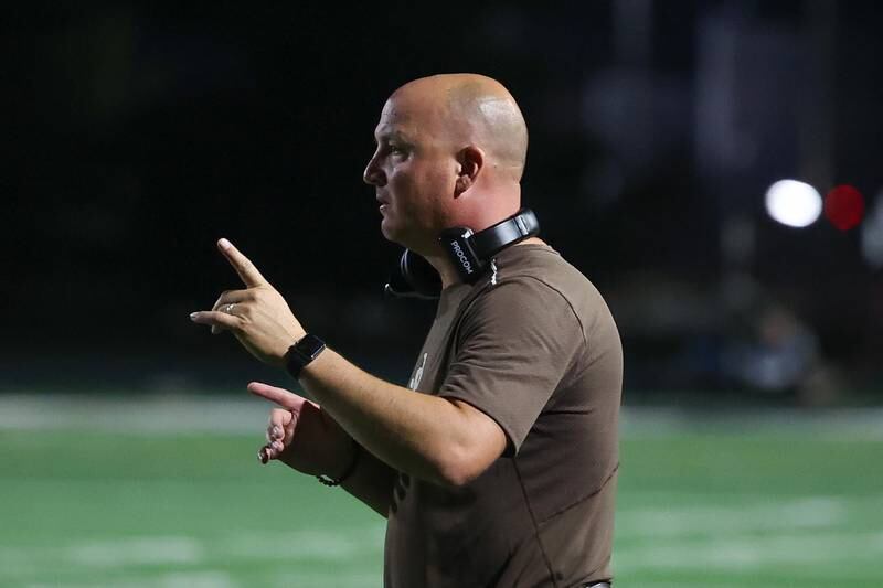Joliet Catholic head coach Jake Jaworski signals in a play against Iowa City on Friday, August 30, 2024 in Joliet.