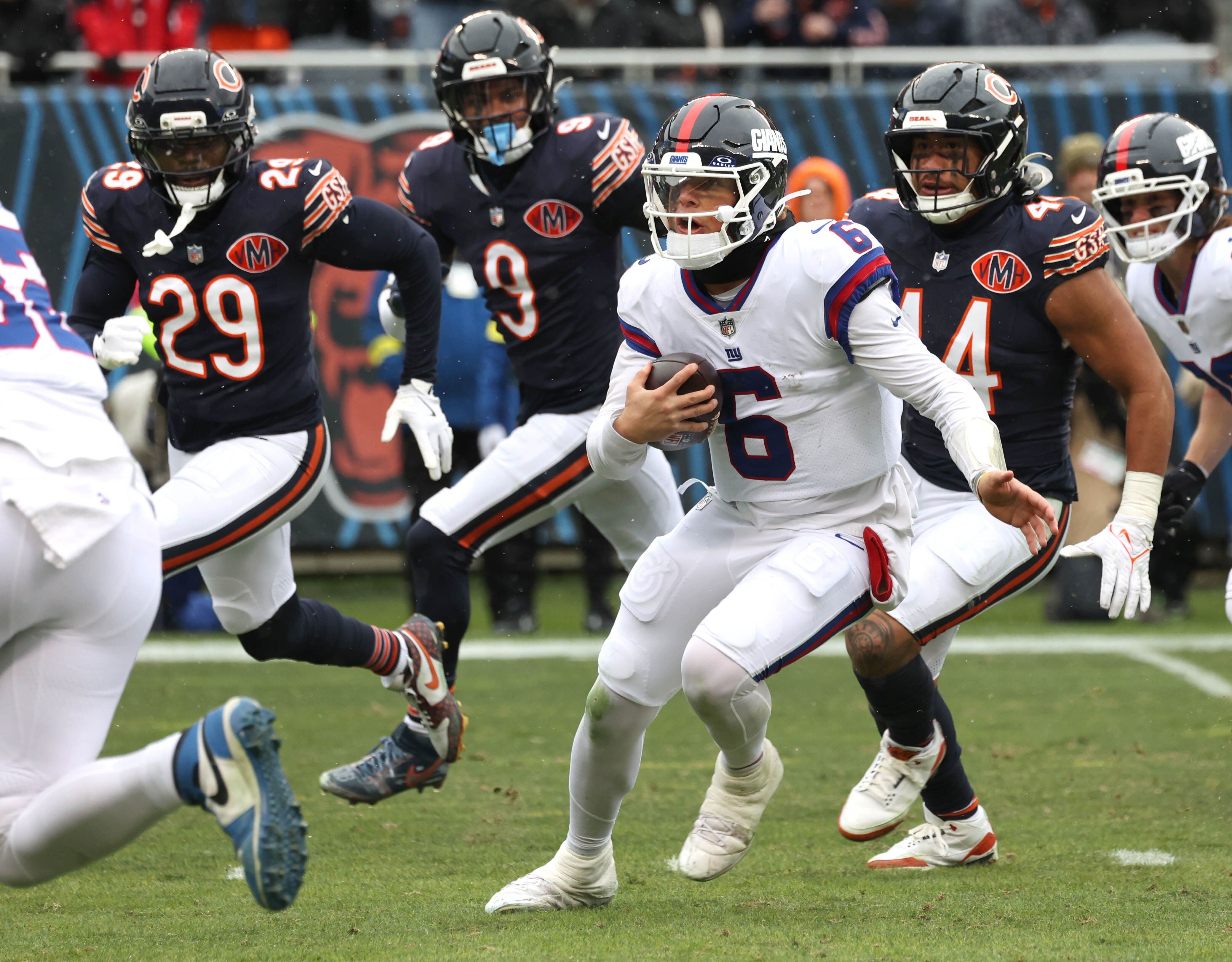 New York Giants quarterback Jaxson Dart scrambles away from the Chicago Bears pass rush Sunday, Nov. 9, 2025, during their game at Soldier Field in Chicago.