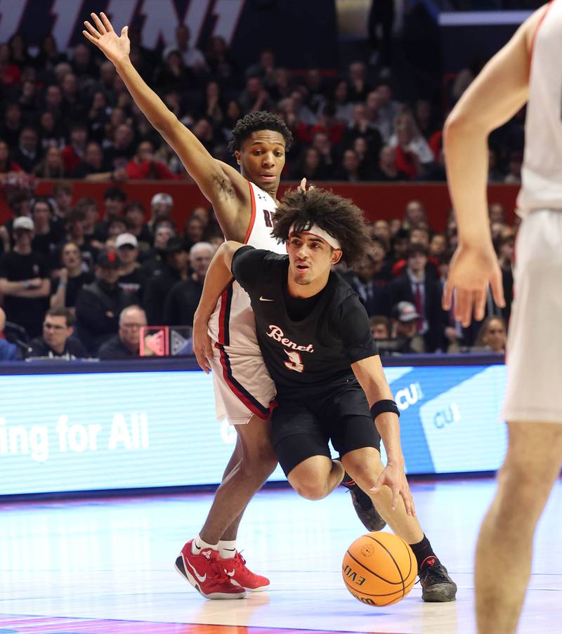 Benet's Jayden Wright drives by Marist's Torrence Tate Jr. Saturday, March 14, 2026, during their IHSA Class 4A state championship game in the State Farm Center at the University of Illinois in Champaign.