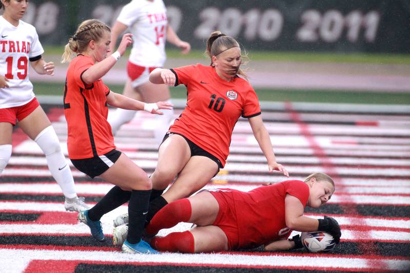 Crystal Lake Central’s Olivia Anderson (left) and Brooklynn Carlson (center) attempt a goal past Triad goal keeper Payton Hartmann during the Class 2A state championship game at North Central College in Naperville on Saturday, June 1, 2024.
