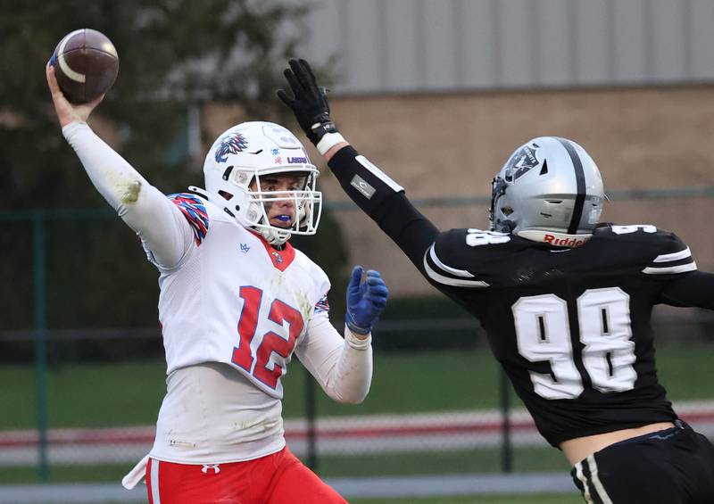 Lakes’ Ean Ankney gets a pass off just before taking a hit from Kaneland's Reiss Thompson Saturday, Nov. 1, 2025, during their first round playoff game at Kaneland High School in Maple Park.