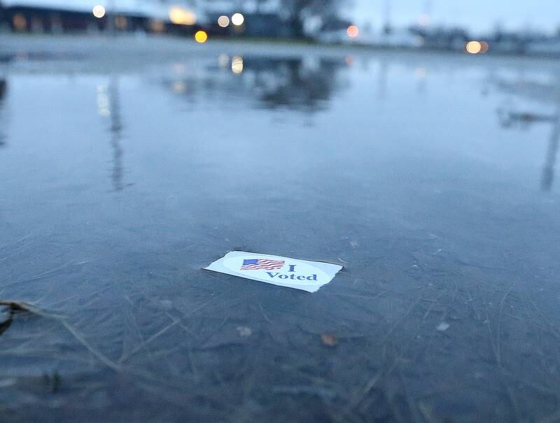 An "I Voted" sticker lays in a puddle of water outside the Moose Lodge on Tuesday, April 4, 2023 in Princeton.