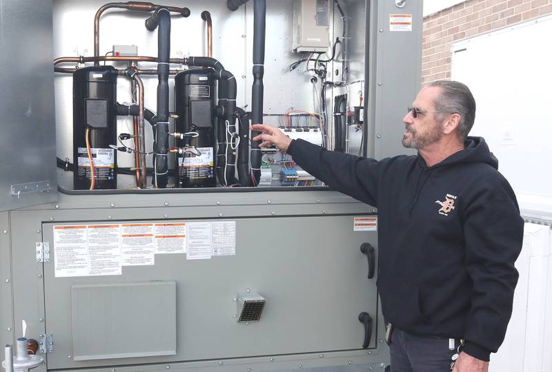 James Orr, with DeKalb School District 428 maintenance, talks Thursday, Nov. 3, 2022, about the features inside of one of the new air conditioning units on the roof of Huntley Middle School.