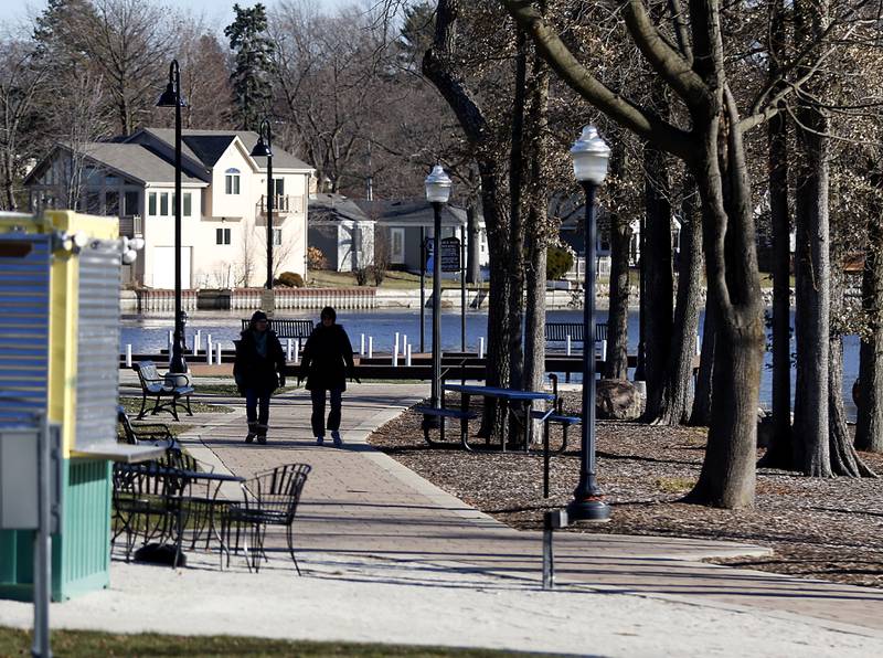 People walk along McHenry's Riverwalk by Boone Creek from Miller Point on Thursday, Dec. 1, 2022.