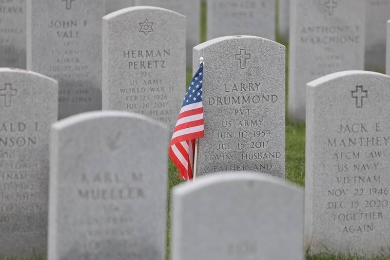 An American flags sits nexts to the headstone of Army Pvt. Larry Drummond at the Abraham Lincoln National Cemetery in Elwood on Saturday, July 29.