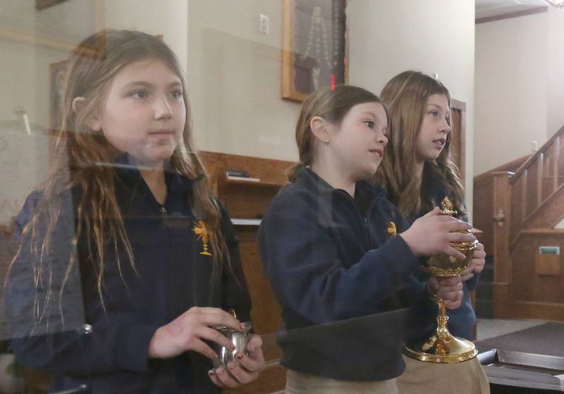 Student at Academy of St. Carlo Acutis Hayden Entwistle, Sadie Drik, and Berkley Keegan, bring up the gifts during the first ever all-school Mass on Friday, Jan. 30, 2026 at St. Joseph’s Catholic Church in Peru.