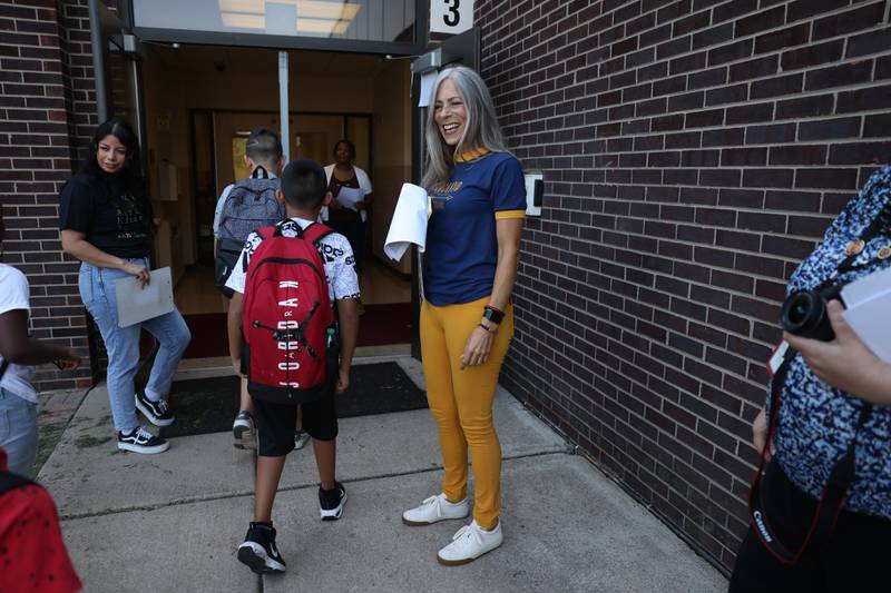 Principal Kim Gordon greets students as they arrive on the first day of school at Woodland Elementary School in Joliet. Wednesday, Aug. 17, 2022, in Joliet.