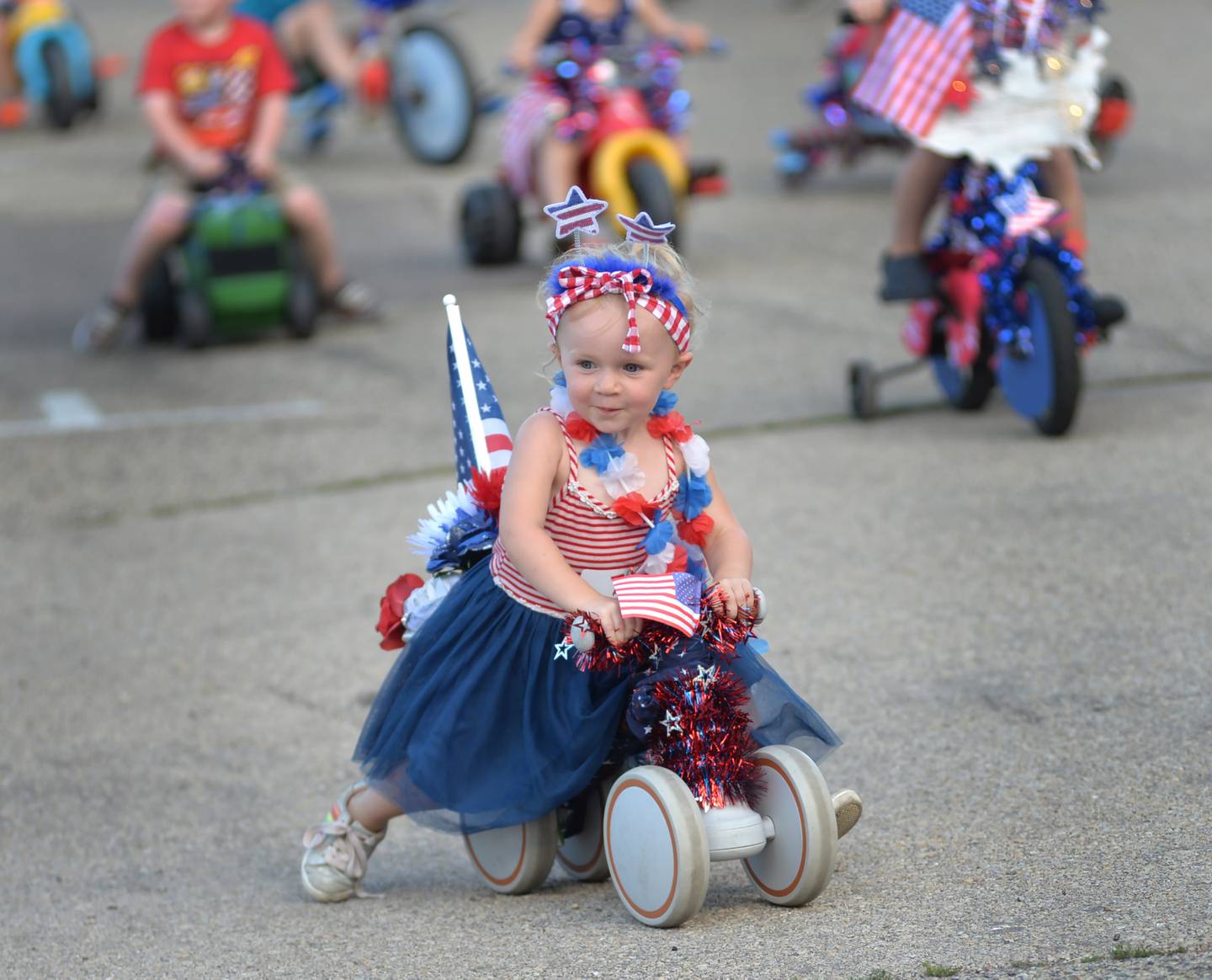 Aurora Anderson, 2 1/2, of Mahomet, rides her trike in the Kiddie Parade at the Let Freedom Ring festival in Mt. Morris on Friday, July 5, 2024.