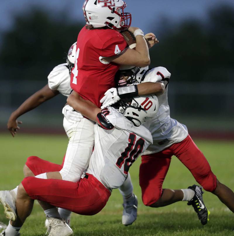 Brian Hill/bhill@dailyherald.com
South Elgin's Jake Sullivan (4) is wrapped up by Glenbard East’s Blake Salvino (10) and Raul Garcia (1)  Friday September 2, 2022 in South Elgin.