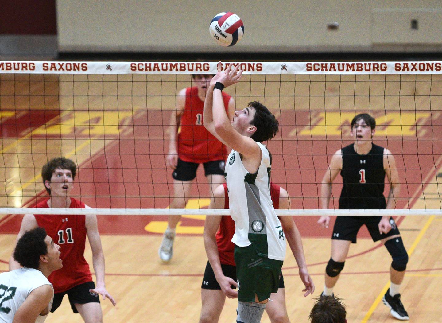 Glenbard West's Trevor Powell sets the ball during Tuesday's boys volleyball sectional championship match against Barrington in Schaumburg.