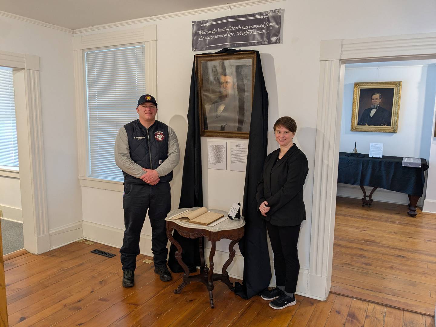 Princeton Fire Chief Scott Etheridge (left) and Bureau County History Center curator Jessica Gray visit to see the portrait of Wright Seaman as well as the original book of meeting minutes for the department. Seaman was the first Fire Chief in Princeton but was killed during the Civil War’s Battle of Shiloh.