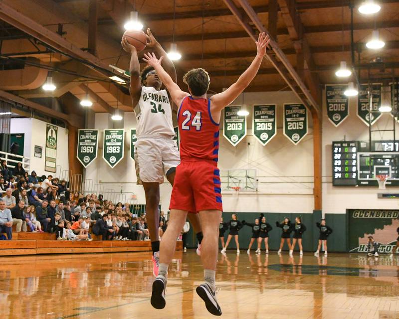 Glenbard West's Logan Glover (34) goes up for a shot in the second quarter while being defended by Glenbard South's Harper Bryan (24) on Monday Nov. 20, 2023, during The district 87 Invite held at Glenbard West.