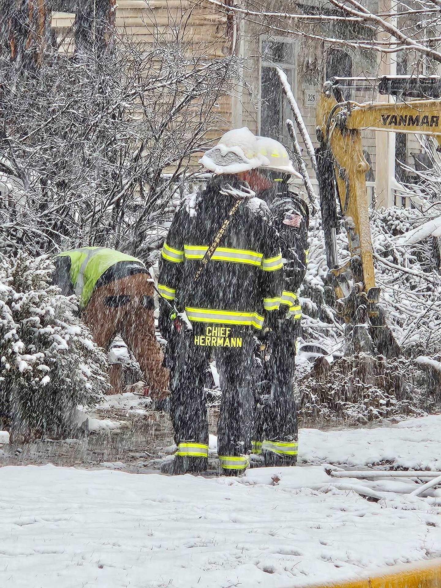 Fire Chief Trevor Hermann of the Hampshire Fire Protection District talks with crew members as they brave a snowy Sunday, March 16, 2025, to battle a multi-home fire, in the 200 block of Market Street in the Riverbend Subdivision in Genoa.