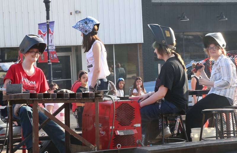 Hall High School mechanics club students ride during the Homecoming parade on Thursday, Sept. 18, 2025 downtown Spring Valley.