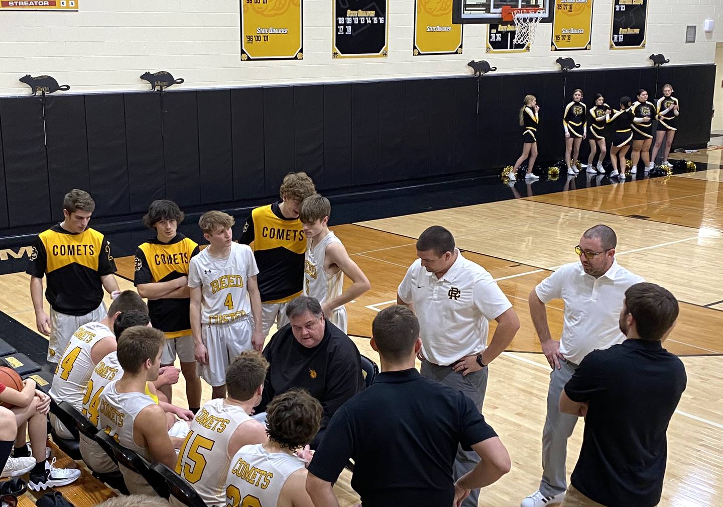 Reed-Custer coach Mark Porter (center) goes over things with his team late in Thursday's overtime home victory over Streator on Jan. 12, 2023.