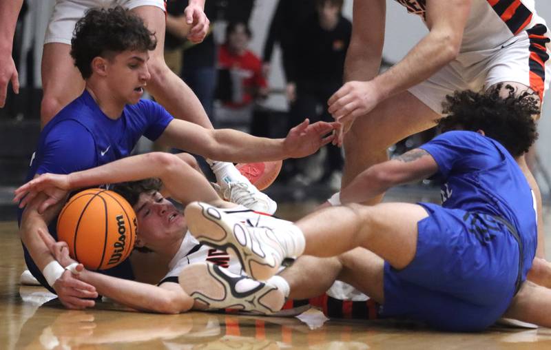 Burlington Central’s  Lucas Kerr, left, and Caden West, right, battle McHenry’s Marko Stojich in varsity boys basketball on Tuesday, Feb. 4, 2025, at  McHenry High School  in McHenry.