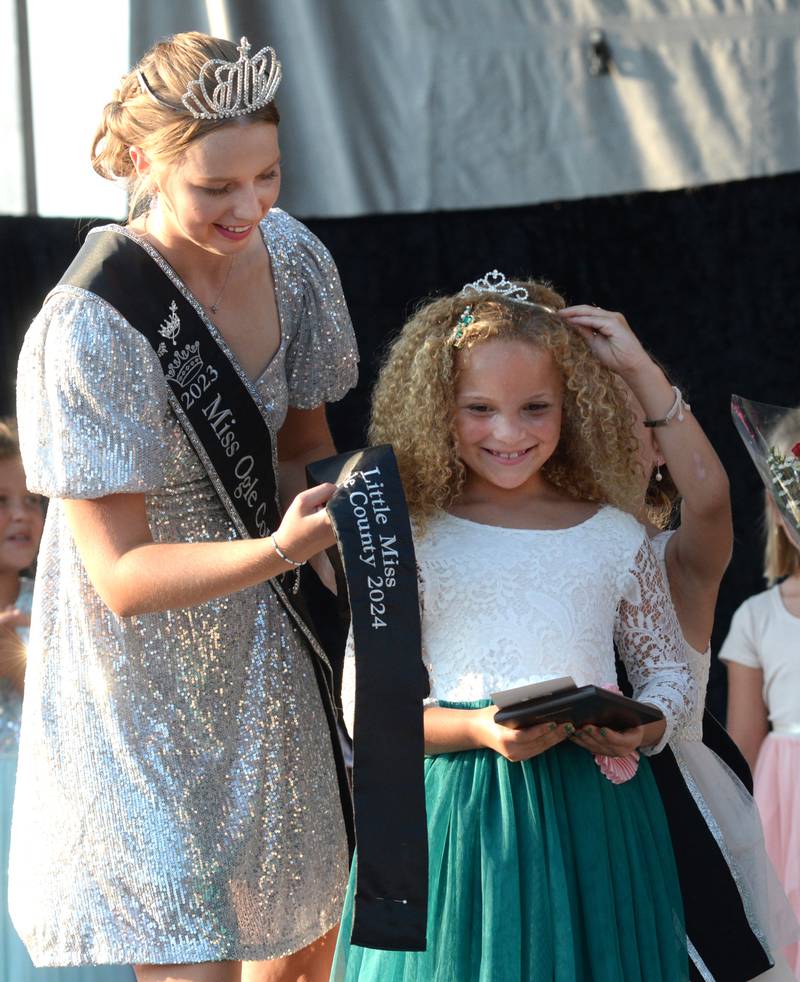 Talia Pope, 7, of Oregon, gets her 2024 Little Miss crown and sash from 2023 Little Miss Quinn Heggen and 2023 Ogle County Fair Queen Lauren Carlson at the Ogle County Fair Pageant on Wednesday, July 31, 2024.
